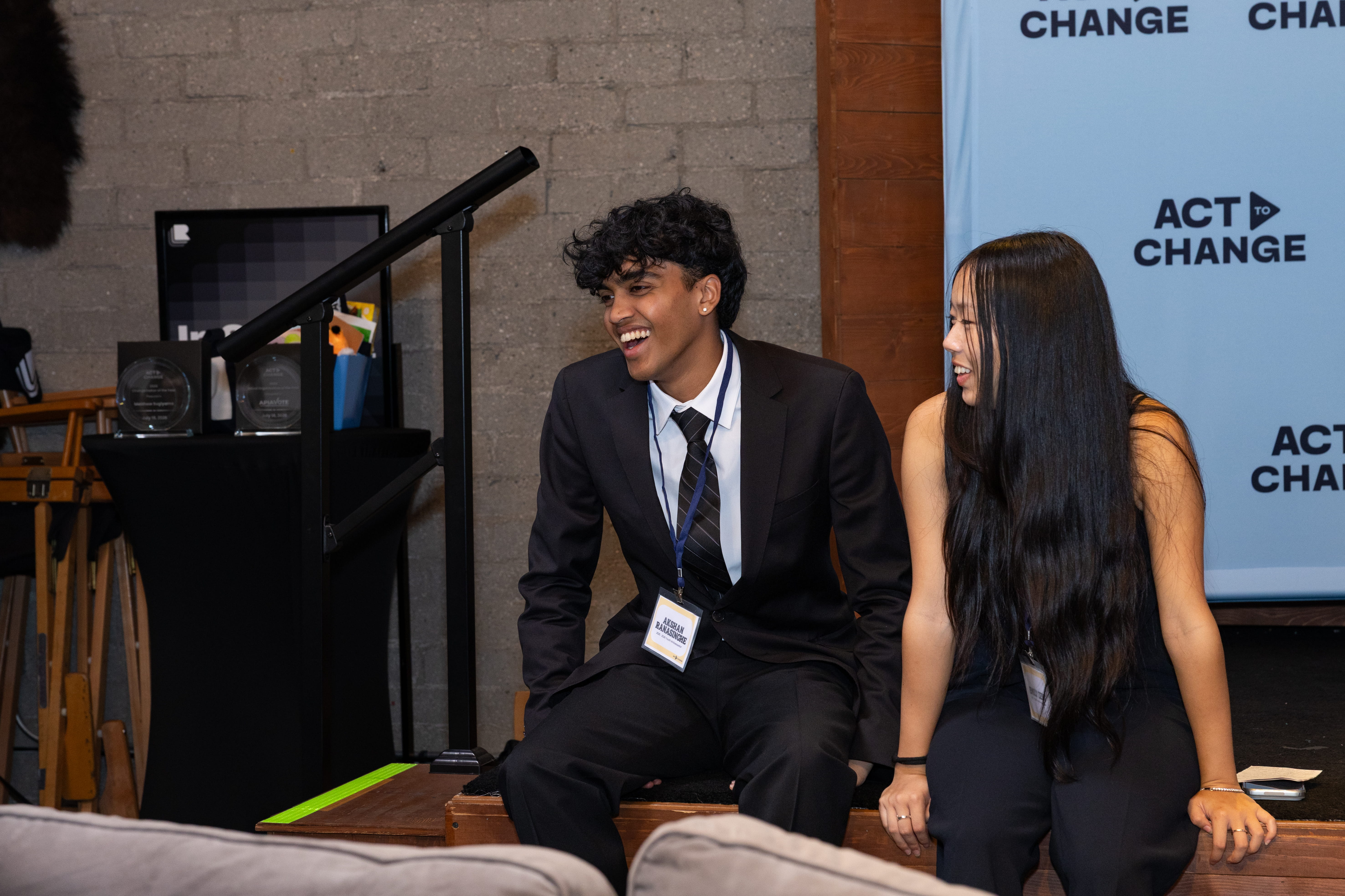 Akshan Ranasinghe, creator of The AAPI Mirror, laughing with a fellow Act to Change Youth Ambassador beside the summit stage in Los Angeles, CA